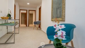 Eine Hotelhalle mit einer Rezeption, einem blauen Sessel und einem Wandbild.