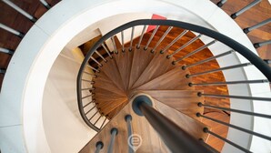 Un escalier en colimaçon avec des marches en bois et des rampes en métal.