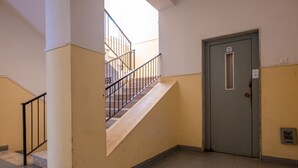 A staircase leading to an upper floor, a door with a small window, and a tiled floor. - Affittacamere Carmè - Suite Lido (Alghero)