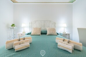 A neatly arranged hotel room with a bed centered between two nightstands, each with a lamp and a small table.
