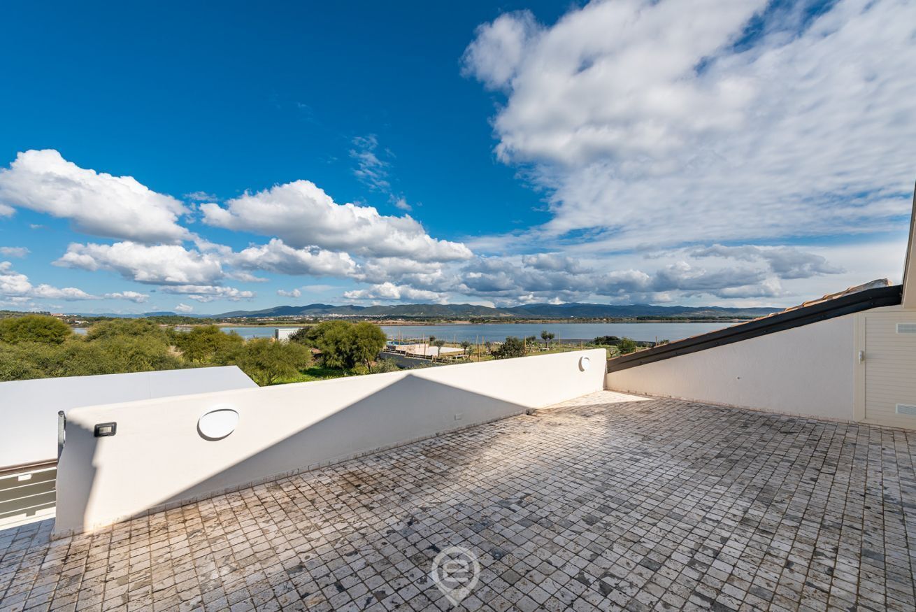 A rooftop terrace with a clear view of a lake and distant mountains.