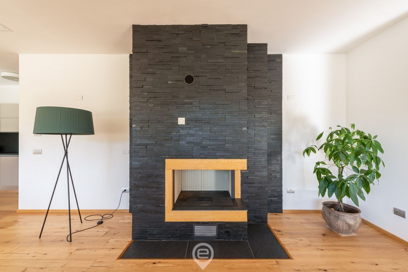 Un salon moderne avec une cheminée intégrée, un lampadaire et une plante en pot.