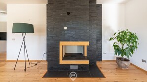 Un salon moderne avec une cheminée intégrée, un lampadaire et une plante en pot.
