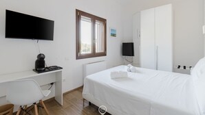 A bedroom with a bed, a desk, a chair, a TV, and a window. - House Adele - Camera 2 (Villa San Pietro)