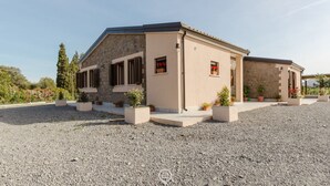 A two-story building with a stone facade, a flat roof, and a gravel driveway. - House Adele - Camera 2 (Villa San Pietro)
