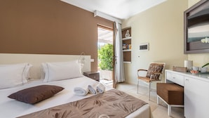 Una habitación de hotel con cama, escritorio, silla y un pequeño balcón.