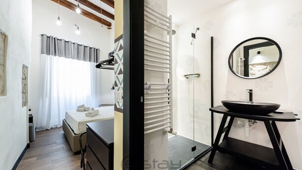 A modern bathroom with a black sink, a mirror, and a towel rack. - KyS Castello - Suite Marina (Cagliari)