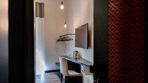 Habitación de hotel moderna con escritorio, silla y televisor de pantalla plana montado en la pared.