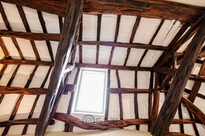 A rustic ceiling with exposed wooden beams and a skylight. - KyS Castello - Suite Stampace (Cagliari)