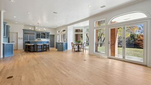 Une cuisine spacieuse avec des meubles bleus, un îlot central et un coin repas comprenant une table et des chaises.