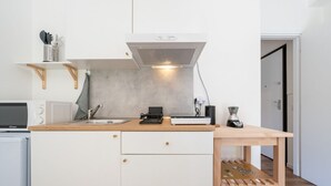 A compact kitchen with a microwave, a coffee maker, and a small sink.