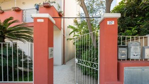 A gated entrance to a building with a number 37 sign, a metal gate, and utility boxes.