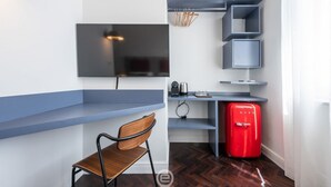 A compact kitchen with a built-in TV, a red fridge, and a wooden chair. - Verso Suites - Suite Quarzo (Cagliari)