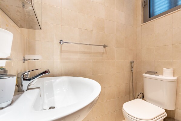 Un baño con un lavamanos blanco, un inodoro y una ducha.