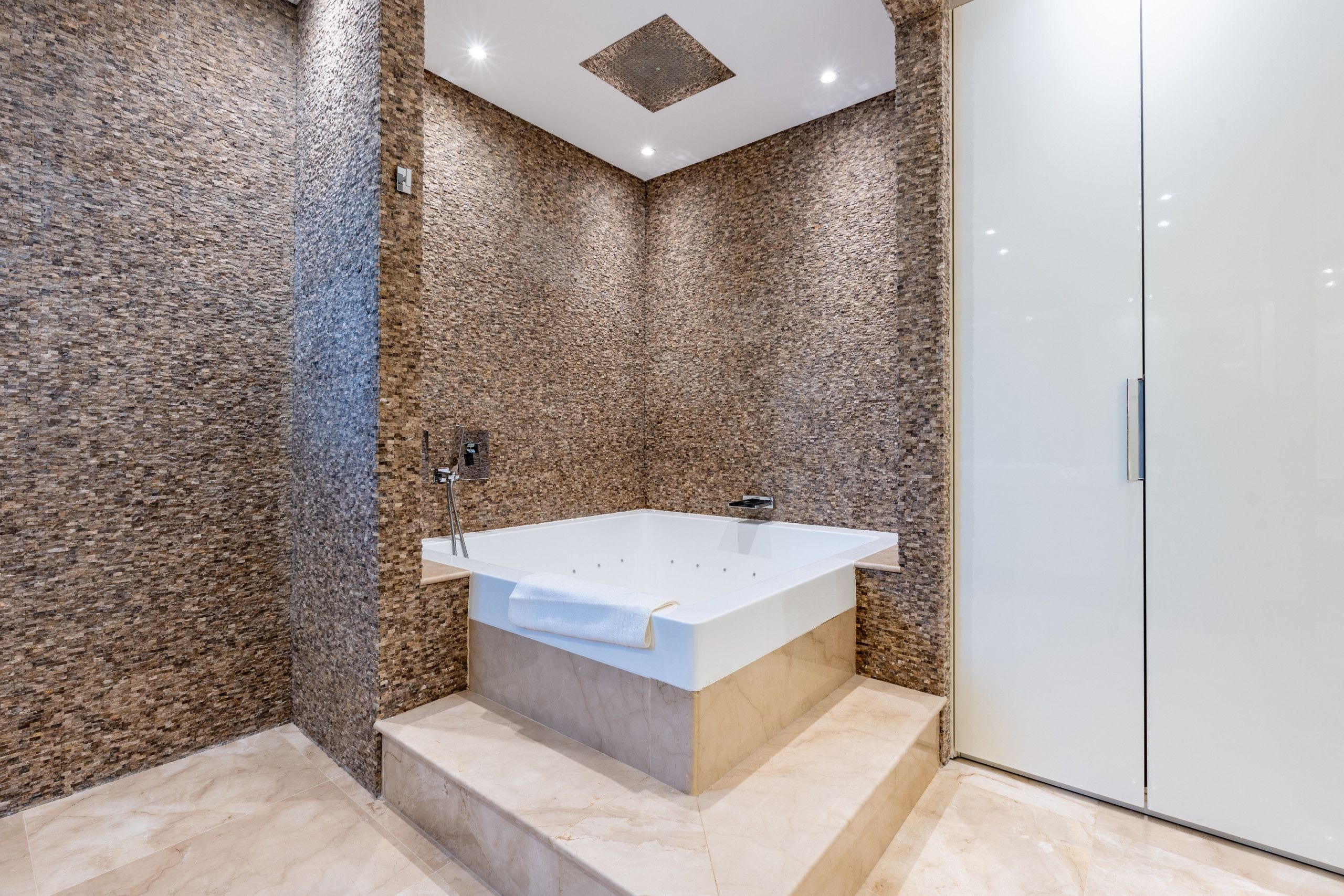 Une salle de bain moderne avec une baignoire sur pieds, une douche et un dressing.