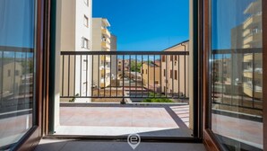 A balcony with a metal railing, a view of adjacent buildings, and a clear blue sky. - Affittacamere Carmè - Suite Porto Conte (Alghero)