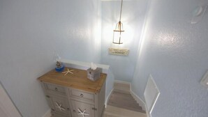 A hallway with a wooden cabinet, a sign reading "TODAY is a MOMENT," and a staircase.