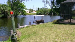 A lakeside property with a dock, a swing chair, and a covered area.