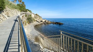 A coastal walkway with a stone railing, leading to a rocky shoreline. - 3 bedroom pet friendly home in Imperia (Imperia)