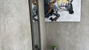 A room with a large mirror, a painting, and a small table with a plant. - Molinos House 1 (Santa Isabel)