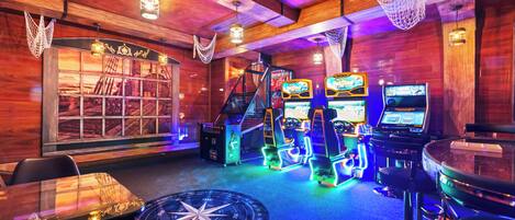 Zona de bar con paredes de madera, luces de neón y juegos de arcade.