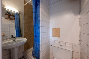 A bathroom with a sink, toilet, and shower curtain. - Studio "Les Bouquetins A" with Balcony and Valley View (South Facing) (La Rosière de Montvalezan)