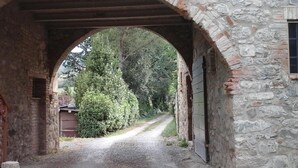 An arched stone bridge leading to a building with a garage door.