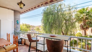 Ein Balkon mit Tisch, Stühlen und einer dekorativen Wandverziierung.