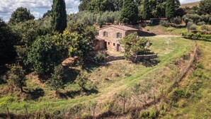 A rustic stone house with a sloped roof, surrounded by lush greenery and trees. - Apartment 'Casamoira' with Private Terrace, Wi-Fi and Air Conditioning (Trequanda)