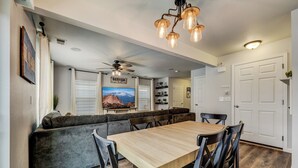 A modern kitchen with a wooden table and chairs, a built-in bench, and a ceiling fan. - Quartz Castle (Castle Rock)