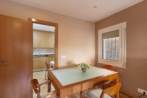 A dining area with a table, chairs, and a window with a view.