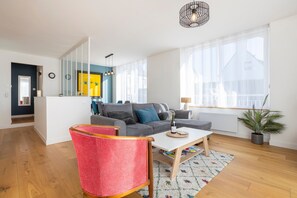 Una sala de estar moderna con un sofá, una mesa de centro y una butaca roja.