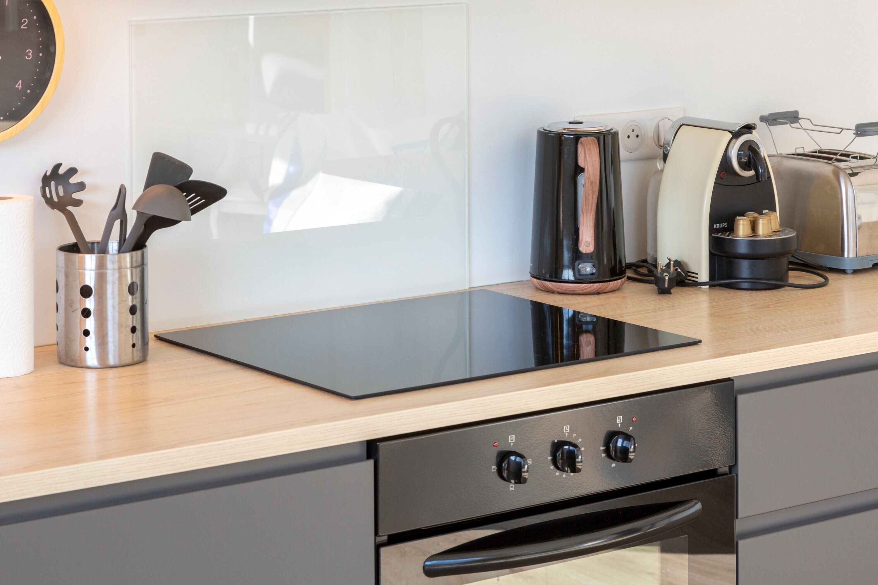 A modern kitchen with a built-in induction cooktop, a toaster, and a coffee maker.