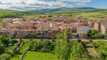 Un pueblo histórico con arquitectura tradicional, una plaza central y colinas verdes circundantes.