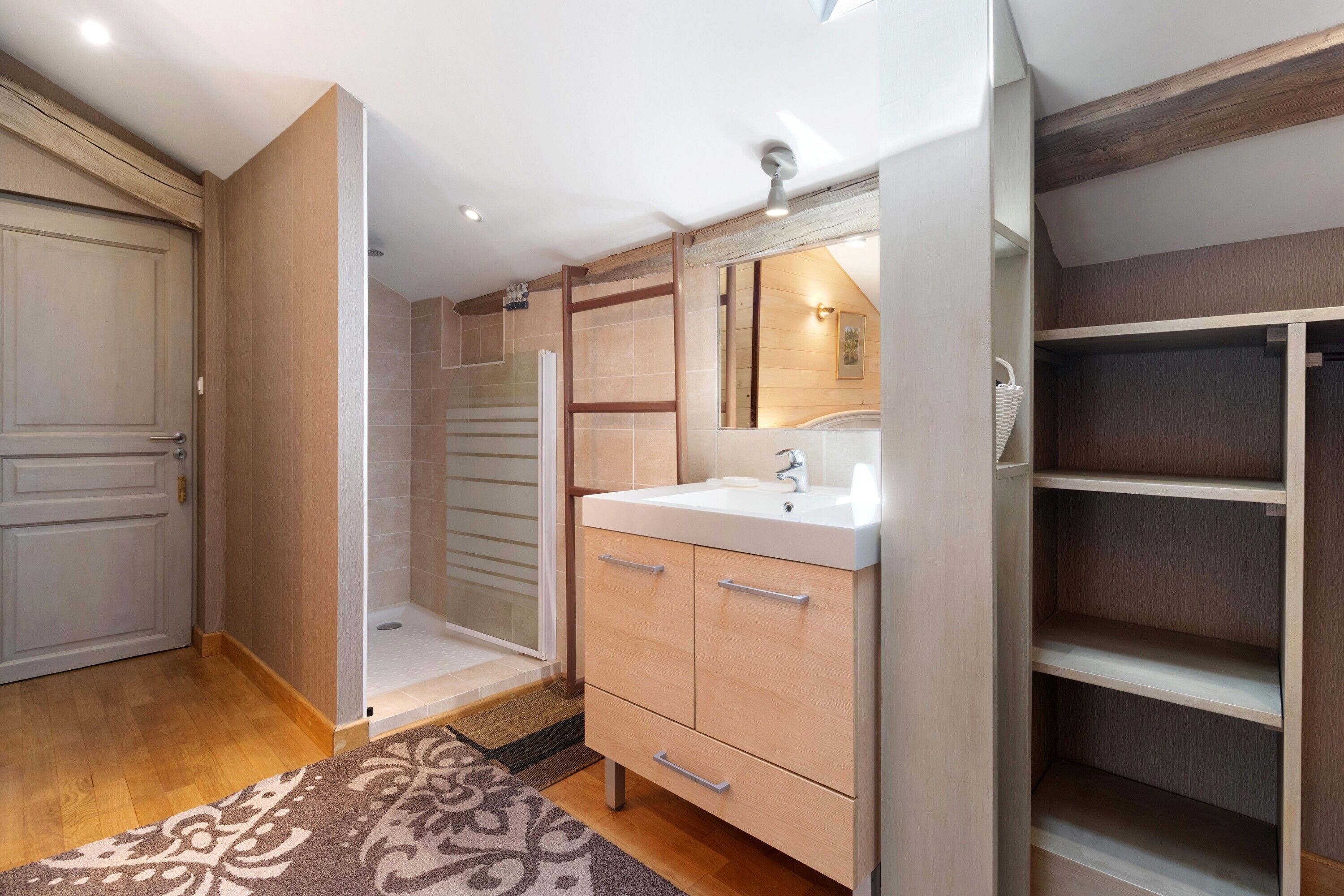 Une salle de bain avec une douche, un lavabo et des placards.