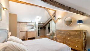 Une chambre à coucher avec un lit, une commode en bois et une chaise.