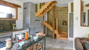 Une cuisine moderne avec une table à manger, des chaises et un escalier en bois.