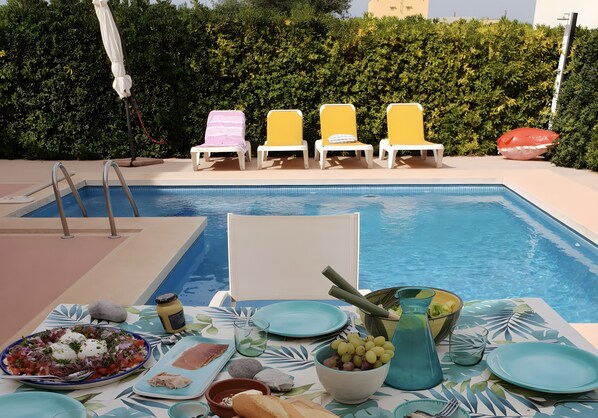 A poolside dining setup with a table, chairs, and a pool. - Holiday Home 'Mateu' with Private Pool, Wi-Fi and Air Conditioning (Colonia de Sant Pere)