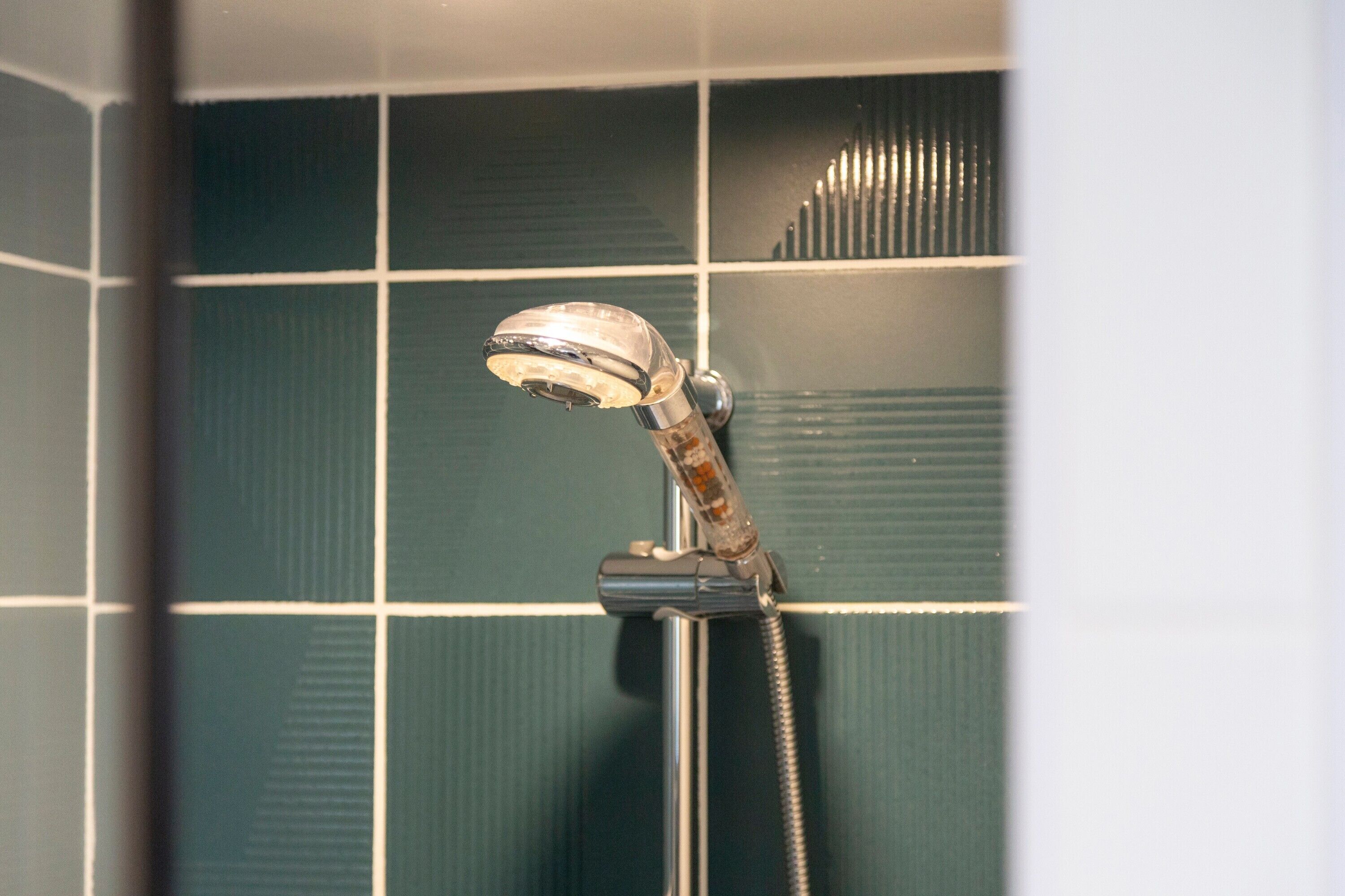 Une douche équipée d’un pommeau de douche mobile fixé au mur.