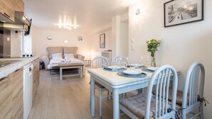 Une cuisine moderne avec un coin repas, un lit et un tableau encadré au mur.