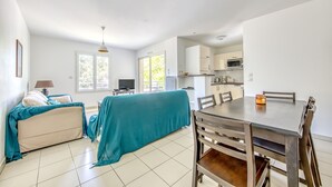 Quarto compacto com cama, mesa de jantar e cozinha compacta.