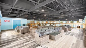A spacious indoor area with a large sectional sofa, wicker furniture, and a fire control room sign.