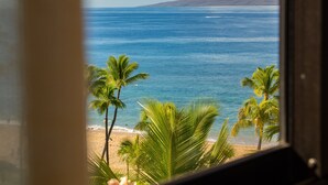 A view of a beach with palm trees and a mountain in the background. - Best of Kaanapali Ali'i Suite 382 - Walk Whalers Village - Ocean Views (Lahaina)