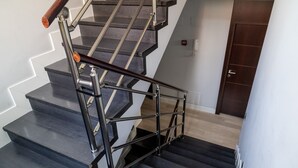 Una escalera con barandilla de metal y peldaños de madera.