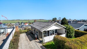 A residential area with houses, a gravel driveway, and a clear blue sky. - 2 bedroom cozy home in Kerteminde (Kerteminde)