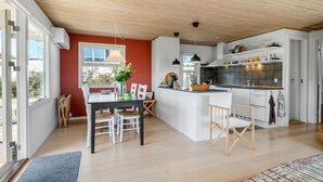 A modern kitchen with a central island, white cabinetry, and a wooden ceiling. - 2 bedroom cozy home in Kerteminde (Kerteminde)