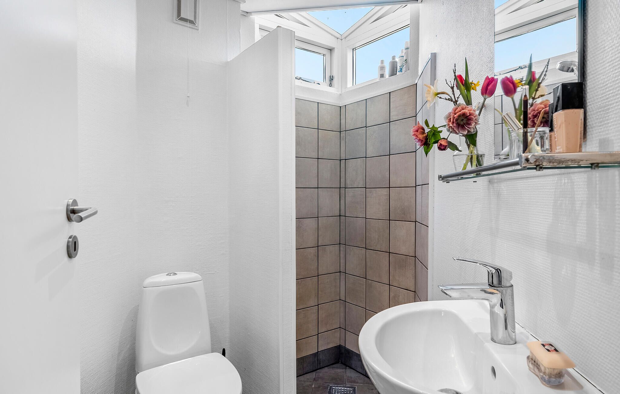 A modern bathroom with a toilet, sink, and shower area.