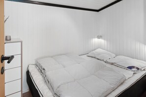 A bedroom with a bed, a bedside table, and a wardrobe.