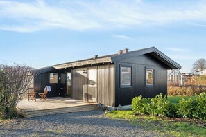 Ein modernes Haus mit einer Holzdiele, einer Tür und einem Fenster.