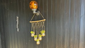A wooden deck with a hanging light fixture and potted plants. - Cozy summer house close to beach and nature (Rønde)
